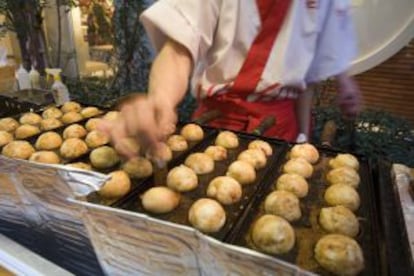 Un cocinero prepara 'takoyaki' en un puesto de la avenida Dotombori, en Osaka (Japón).