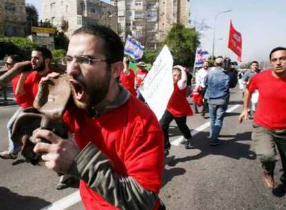 Varios israelíes protestan en Jerusalén contra el Gobierno con trozos de misiles lanzados el sábado.