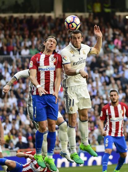 Filipe Luis (i) salta para golpear el balón junto con Gareth Bale.