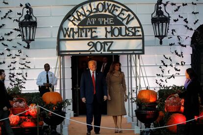 Donald Trump acompañado de su esposa, Melania, esperan la llegada de los más pequeños para hacer entrega de los caramelos durante la celebración de Halloween, en la Casa Blanca.