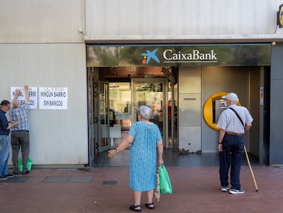 Vecinos del barrio de la Trinitat Nova de Barcelona, ante la oficina, en su último día de apertura.