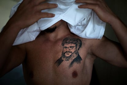 Taysir, 30 años, funcionario, se cubre la cara mientras posa para una foto mientras muestra un tatuaje del líder de Hezbollah, Hassan Nasrallah, en el sur de Beirut, Líbano. Se lo tatuó hace cinco meses como una expresión de 'profundo amor' para el hombre que dice protege el Líbano del Estado Islámico y otros extremistas sunitas que luchan en los países vecinos.