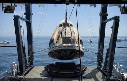 Cápsula da Crew Dragon, da SpaceX, é resgatada com os dois astronautas por embarcação após pouso no domingo.