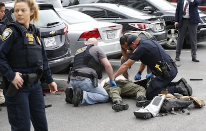 Los oficiales de policía atienden a un tirador herido en un estacionamiento después de que abriese fuego en el Edificio Federal de Earle Cabell, en el centro de Dallas, Estados Unidos.