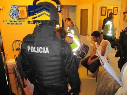 La policía en uno de los registros con uno de los 28 detenidos por tráfico de menores. 