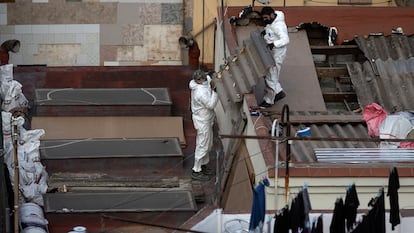 Dos operarios retiran un tejado de amianto, en Barcelona en 2022.