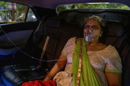 Una mujer recibe oxígeno en el interior de un coche en el exterior de un templo de Ghaziabad, este sábado.