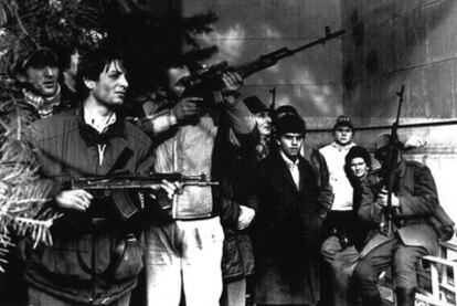 Civiles armados rumanos abren fuego contra fuerzas leales al dictador Ceaucescu en el centro de Bucarest, en 1989.