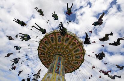 Varias personas se divierten en unas sillas voladoras durante el cierre del Oktoberfest, en Múnich.