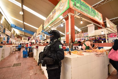 A police officer guards chicken stalls in Chilpancingo (Guerrero), after the murder of eight merchants in June 2022.