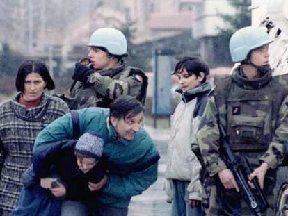 <b><i>Cascos azules</b></i> franceses en Sarajevo cubren del fuego de los francotiradores a un padre con su hijo en brazos, en marzo de 1995.