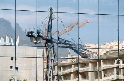 Reflejo de una grúa y de unas construcciones en la Milla de Oro de Marbella (Málaga), en una imagen tomada en julio de 2003. La Milla de Oro es como se conoce a los 4 kilómetros que separan el núcleo urbano de Marbella de Puerto Banús y alberga lujosas viviendas y hoteles.