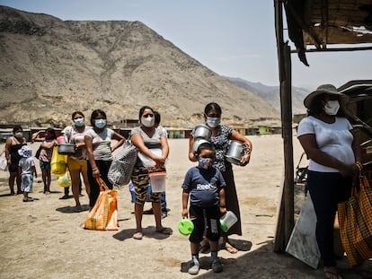 Un grupo de personas esperan recibir alimentos del comedor social de Comas, en la periferia de Lima.