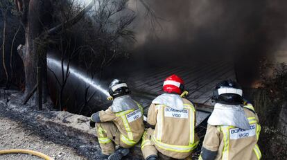 Bombers treballen en l'incendi d'una nau a Puxeiros, Pontevedra.