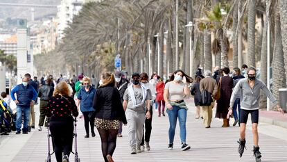 Varias personas pasean por el Paseo Marítimo de Almería con mascarillas durante la pandemia.