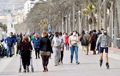 Varias personas pasean por el Paseo Marítimo de Almería con mascarillas durante la pandemia.