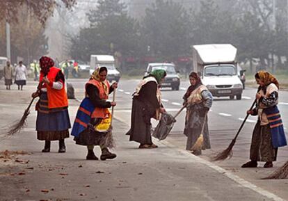 Un grupo de empleadas municipales limpia los alrededores del palacio presidencial de Bucarest en vísperas  de una  visita de George W. Bush  en 2002.