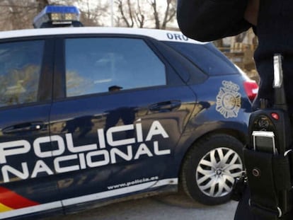 Un agente y un coche patrulla de la Policía Nacional