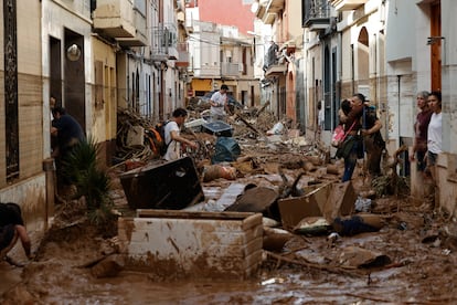 PAIPORTA (VALENCIA), 31/10/2024.- Varias personas trabajan en las labores de limpieza y desescombro en Paiporta, Valencia, este jueves. La Comunitat Valenciana intenta recuperarse de la peor dana del siglo en España, que ha dejado casi un centenar de muertos en esa región, además de un inmenso escenario de daños en carreteras, calles e infraestructuras de numerosas localidades. EFE/ Biel Aliño
