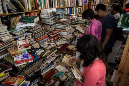 Varios clientes buscan libros en A través del espejo.