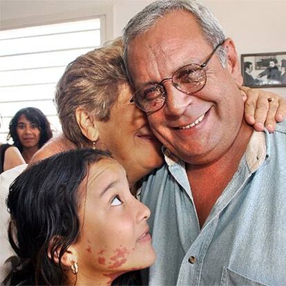 Blanca Reyes abraza a su marido, Raúl Rivero, en la casa de ambos. Junto a ellos, Jenny, la niña criada por la pareja.