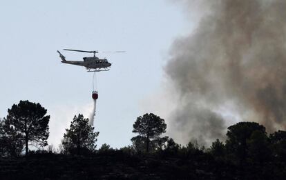 Un helicóptero lanza agua durante las labores de extinción del incendio que ya afecta a miles de hectáreas en Valencia, el 7 de agosto.
