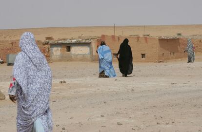 Varias mujeres caminan hacia sus casas de adobe en el campo de refugiados de los saharauis del en Tinduf (Argelia).