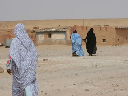 Varias mujeres caminan hacia sus casas de adobe en el campo de refugiados de los saharauis del en Tinduf (Argelia).