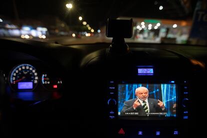 Un automovilista observa hoy el debate presidencial en Sao Paulo.