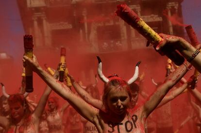 Activistas de las organizaciones AnimaNaturalis y PETA, durante la concentración que han llevado a cabo en la Plaza del Ayuntamiento de Pamplona donde, en sus cuerpos desnudos han escrito lemas contra las corridas de toros y han roto banderillas por los toros que serán lidiados durante los Sanfermines.