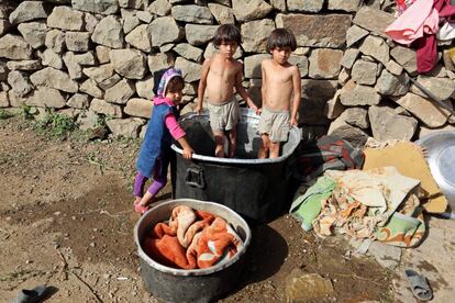 Niños dentro de un barreño donde sus madres lavan la ropa, en las montañas de Dhalamlam, en Jafariya.