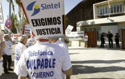 Un grupo de personas protesta con pancartas a la entrada de la Audiencia Nacional en San Fernando de Henares, donde se celebra el juicio oral contra los ocho acusados de la quiebra de Sintel -antigua filial de Telefónica-, quienes se enfrentan a un presunto delito societario, de insolvencia punible y contra la Hacienda Pública, además de a una fianza de 300 millones. EFE/Archivo