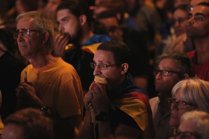 Un manifestante escucha la comparecencia del president Carles Puigdemont durante la concentración a favor de la independencia.
