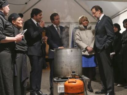 Rajoy y Aguirre ante la olla de cocer pulpo, en la cena de los militantes del PP en Collado Villalba (Madrid), el jueves pasado. 