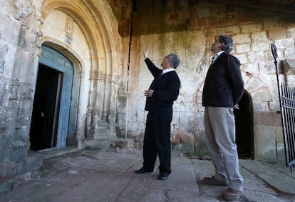 El responsable de Patrimonio del Obispado de Palencia, José Luis Calvo, señala la grieta en la que se ha encontrado la pieza tallada en piedra. A la derecha, el descubridor del hallazgo, José María Menéndez Jambrina.