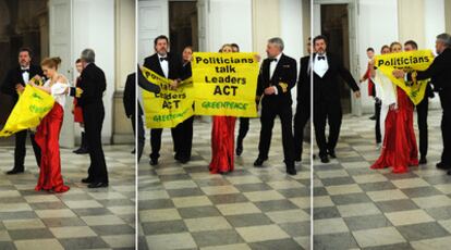 Juan López de Uralde, a la izquierda, despliega una pancarta tras colarse en la cena de gala.