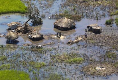 Dos semanas después del paso del ciclón Idai por el sureste de África, algunas zonas continúan inundadas e incomunicadas. En Mozambique hay 1,85 millones de afectados; en Malawi, 869.000 y en Zimbabue, 270.000. En la imagen, una familia en Beira afuera de sus chozas aún inundadas.