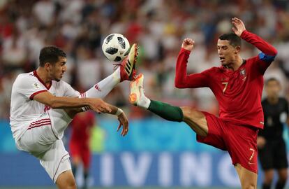 Cristiano Ronaldo e Majid Hosseini disputam a bola durante a jogo da fase de grupos entre Irã e Portugal, em 25 de junho de 2018.