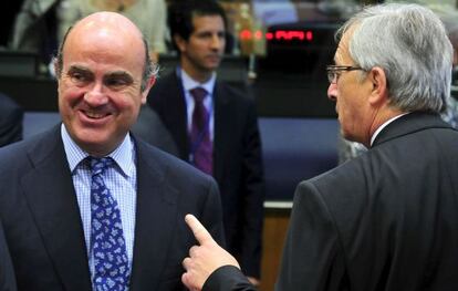 El ministro de Econom&iacute;a, Luis de Guindos, conversa con el presidente del Eurogrupo, Jean Claude Juncker.