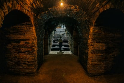 Marta Sertaje sale de la cueva del vino de Adega A Coroa, en A Rúa. La estructura subterránea conserva una inscripción del siglo XVIII.