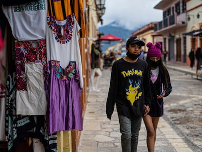 Dos jóvenes pasan frente a un puesto de artesanías en San Cristóbal de las Casas, Chiapas.