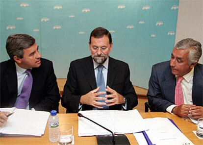 Mariano Rajoy, flanqueado por Ángel Acebes y Javier Arenas, ayer en el Comité Ejecutivo del PP.