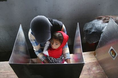 Una madre vota junto a su hija en Lumajang (Indonesia), 9 de abril de 2014.