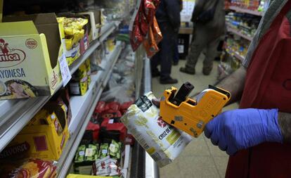 Un empleado remarca el precio de un paquete de yerba mate en un supermercado de Buenos Aires.