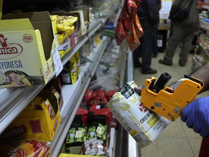 Un empleado remarca el precio de un paquete de yerba mate en un supermercado de Buenos Aires.