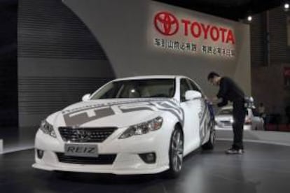 Un operario limpia la carrocería de un Toyota Reiz expuesto en el 14º Salón del Automóvil de Shanghaí (China). EFE/Archivo