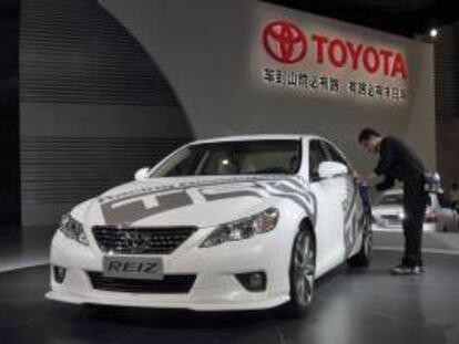 Un operario limpia la carrocería de un Toyota Reiz expuesto en el 14º Salón del Automóvil de Shanghaí (China). EFE/Archivo