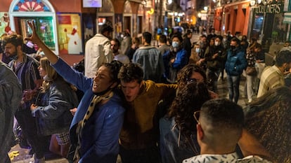 Decenas de personas cantando, gritando y bailando en la calle Espoz y Mina, en Madrid, pasada la hora del toque de queda.