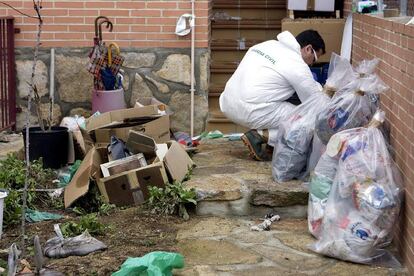 Un agente de la policía judicial  clasifica los restos de basura con los que convivían los Lee.