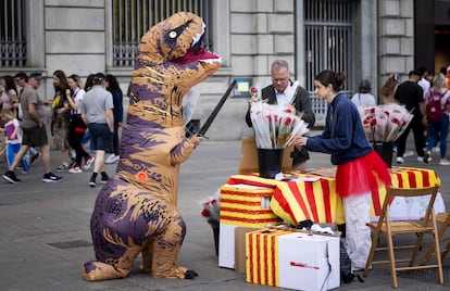 Una persona disfrazada de dragón, en honor a la leyenda de Sant Jordi y el dragón, sorprende a la gente por las Ramblas de Barcelona.
